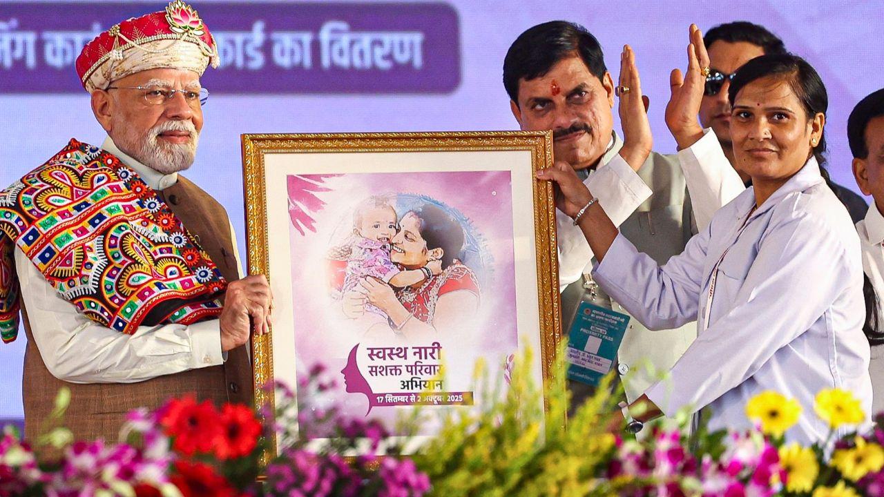 Prime Minister Narendra Modi felicitated with a poster of swasth nari sashakt parivar abhiyaan during the foundation stone laying ceremony of the PM MITRA Park.